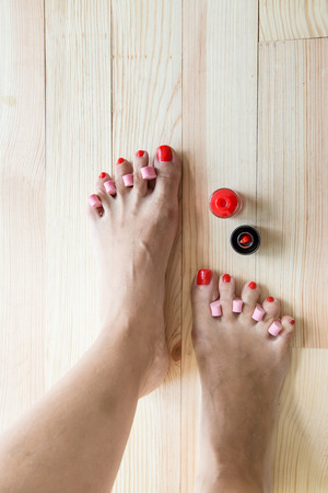 Woman painting toe nails and pedicureの写真素材