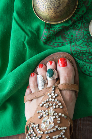 Woman legs putting on shoes with accessoriesの写真素材