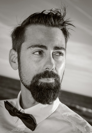 Hipster man with beard and hat on the beach and the forestの写真素材