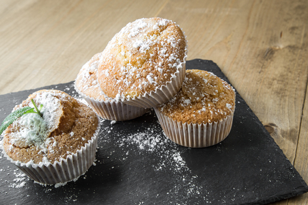 Homemade muffins with star anise, cinnamon and mint on old wooden tableの写真素材