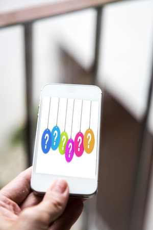 Mobile concept question: woman hands holding a mobile phone with the display of a question markの写真素材