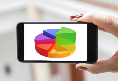 Mobile concept statistics: woman hands holding a mobile phone screen with a graphic of statistics