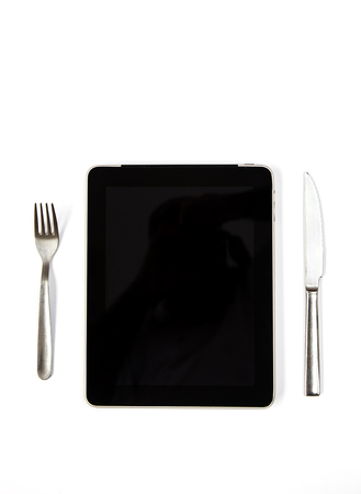 Black tablet with knife and fork isolated verticalの写真素材