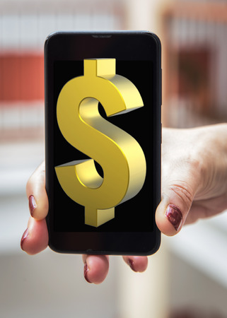 Mobile concept dollar sign: Woman hands with dollar sign in the mobile phone screenの写真素材