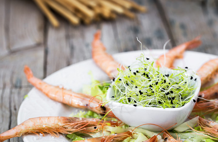 Close-up of several cooked shrimps on plate served with greeneryの写真素材