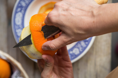 Unrecognizable person peeling orange skin offの写真素材