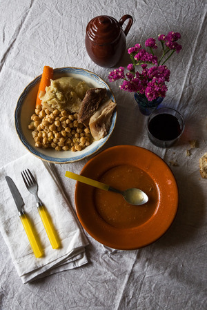 Cooked hot soupe and other food on table with yellow utensils.From aboveの写真素材