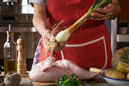 Close-up of unrecognizable woman cooking chicken in the kitchenの写真素材