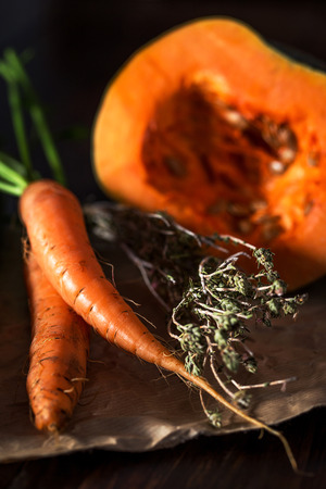 Carrot bunch with tops bound by rope on wooden background. From aboveの写真素材
