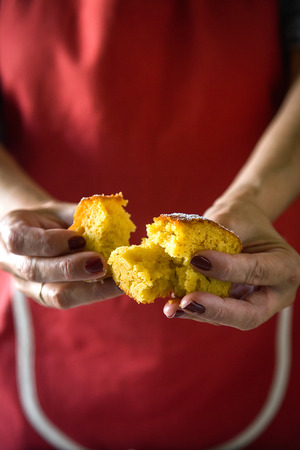 Woman's arms slicing cake on black board in morningの写真素材