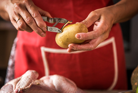 Close-up of unrecognizable woman cooking chicken in the kitchenの写真素材