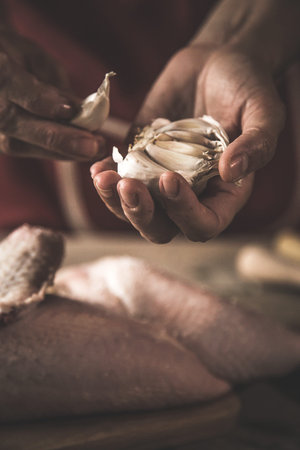 Close-up of unrecognizable woman cooking chicken in the kitchenの写真素材