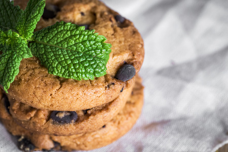 freshly baked chocolate chip cookies on rustic old wooden tableの写真素材