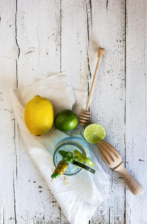 freshly made drink gin and tonic with lime and cucumber slices and mint on old wooden tableの写真素材