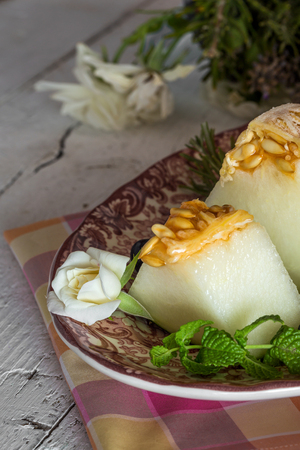 Fresh melon with mint and rosemary on the wooden table, selective focusの写真素材