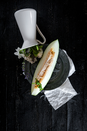 Fresh melon with mint and rosemary on the wooden table, selective focusの写真素材