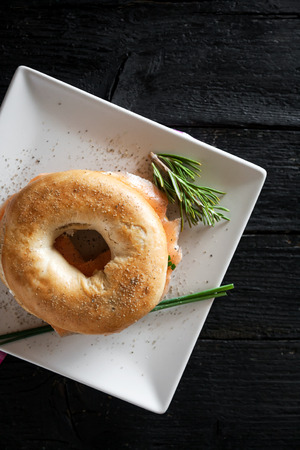 bagel with a smoked salmon and cream cheese on old wooden tableの写真素材
