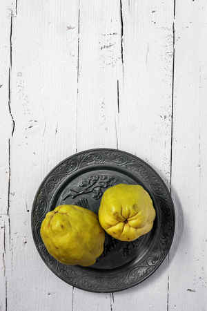 Fresh quinces on wooden table with napkinの写真素材