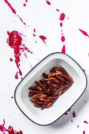 spicy red chillies in plate on color paperの写真素材