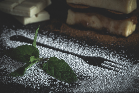 Cheesecake and white chocolate with figs, mint and strawberry jam on old wooden tableの写真素材