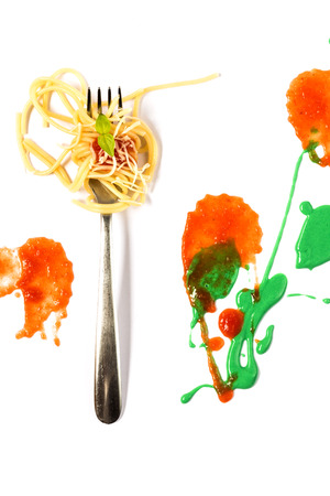 Italian pasta with tomato and basil on fork on white cardboardの写真素材