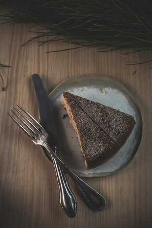 Delicious cake on old wooden table with dark lightの写真素材