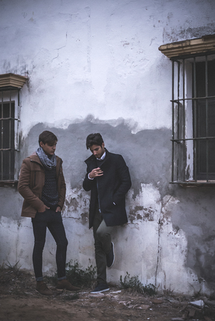 Portrait of two young man posing with fashionable clothes outdoorsの写真素材