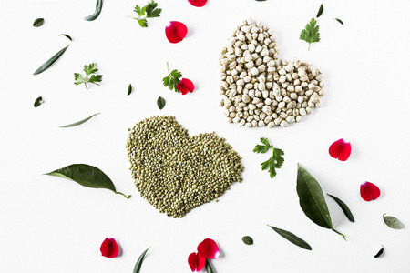 Bowls of various vegetables (lentils, chickpeas and beans) with white and flowers backgroundの写真素材