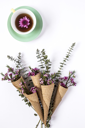 Cup of tea with Floral background and green leaves on white background. Flat lay, top viewの写真素材