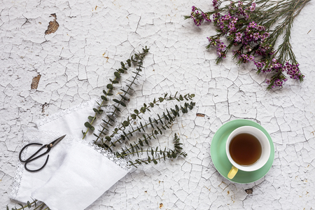 Cup of tea with Floral background and green leaves on white background. Flat lay, top viewの写真素材