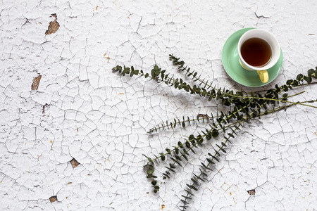 Cup of tea with Floral background and green leaves on white background. Flat lay, top viewの写真素材