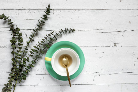 Cup of tea with Floral background and green leaves on white background. Flat lay, top viewの写真素材