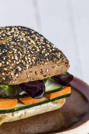 Vegan burger with fresh vegetables on rustic backgroundの写真素材