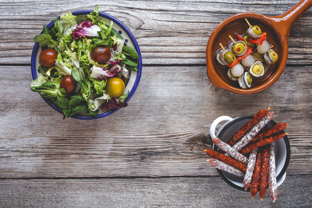 Assortment of sausages typical of Spain. Ham; sausage; cheese; Over old wooden board. From aboveの写真素材