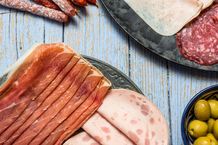 Assortment of sausages typical of Spain. Ham; sausage; cheese; Over old wooden board. From above