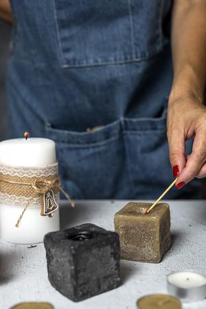 Unrecognizable woman hands lighting candles Christmas days, preparing the decorationの写真素材