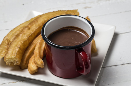 Typical Spanish churros with hot chocolate sauceの写真素材