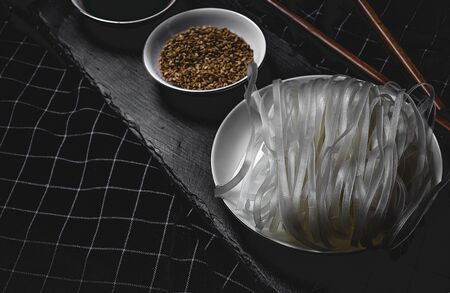 Vegan noodles raw with peas, peppers, onion and zucchini on dark background. Healthy food. Asian foodの写真素材