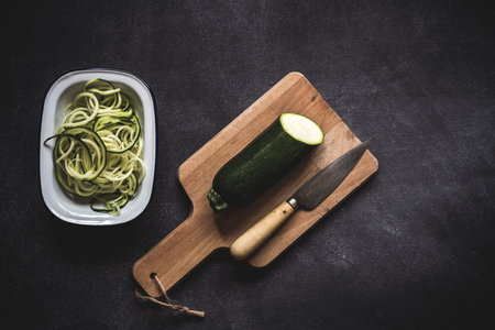 Fresh zucchini on a black background on old table