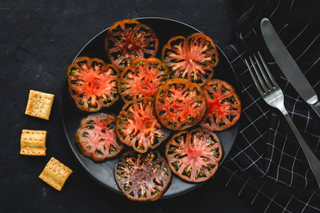 Fresh tomato carpaccio with olive oil and aromatic herbs from above. Flat lay. Vegan foodの写真素材