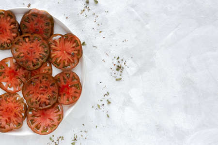 Fresh tomato carpaccio with olive oil and aromatic herbs from above. Flat lay. Vegan foodの写真素材