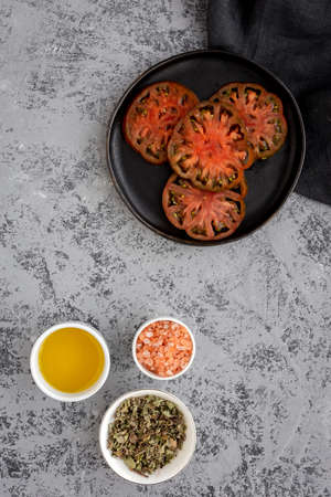 Fresh tomato carpaccio with olive oil and aromatic herbs from above. Flat lay. Vegan foodの写真素材