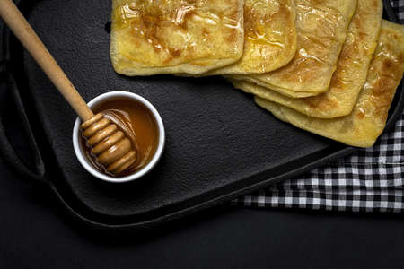 Homemade and traditional Arabic rghaif or msemen with honey and cream cheese on dark background. Moroccan Foodの写真素材