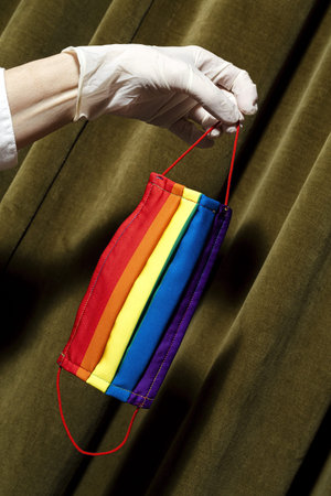 Unrecognizable woman's hands showing homemade fashion and design LGBT masks for covid-19 protection....