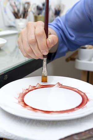 Unrecognizable woman hands working painting ceramic dishes. Craftsmanship conceptの写真素材