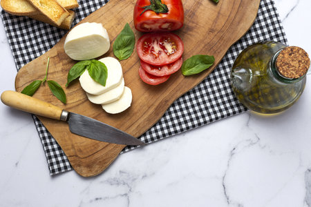 Homemade Italian caprese salad with sliced tomatoes, mozzarella cheese, basil, olive oil and salt.の写真素材