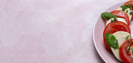 Homemade Italian caprese salad with sliced tomatoes, mozzarella cheese, basil, olive oil and salt.の写真素材