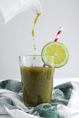 Homemade vegetable green smoothie with apple, cucumber, mint and lime. Detox concept. Vegan drinkの写真素材