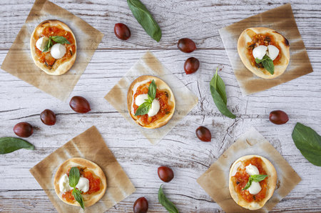 Homemade mini pizzas margarita with tomato, mozzarella and basil from above.Traditional Italian foodの写真素材