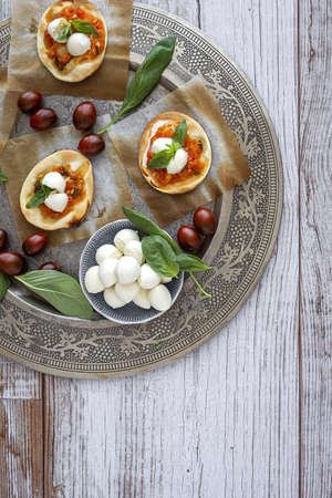 Homemade mini pizzas margarita with tomato, mozzarella and basil from above.Traditional Italian foodの写真素材